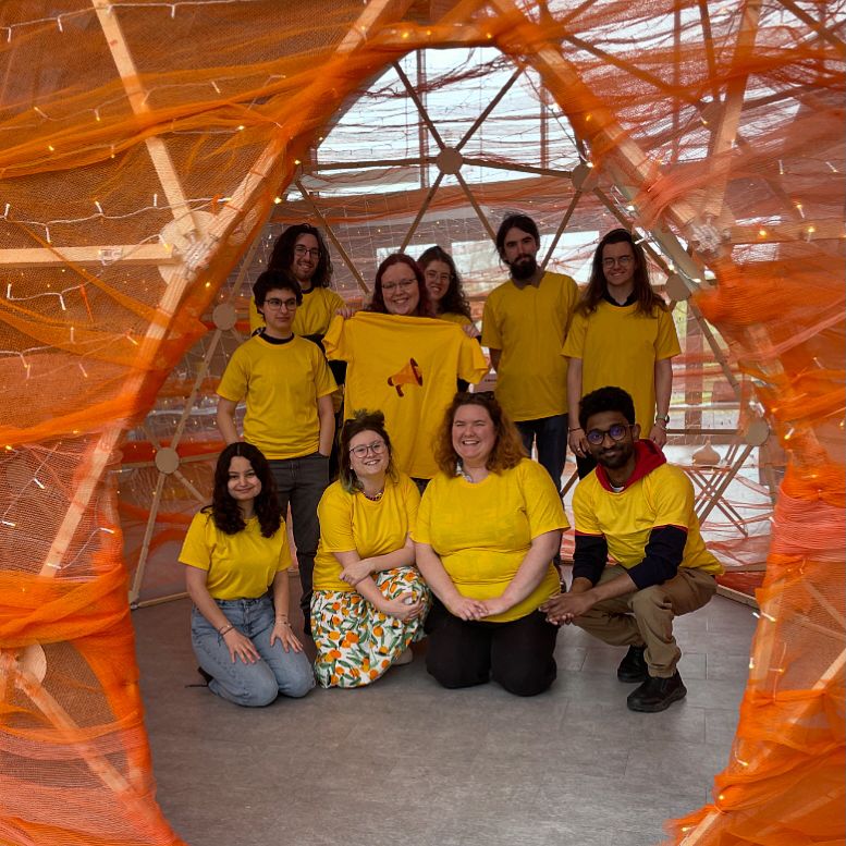 A photo of 10 Speak Volumes Volunteers, wearing matching yellow shirts